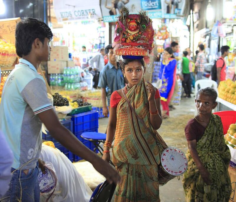A girl asks for donations in lieu of blessings from the Hindu goddess from visitors at the Crawford Market. Subhash Sharma for The National