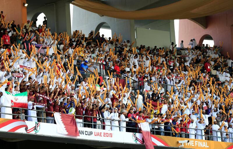 Qatar fans wave flags before the final in Abu Dhabi . Thaier Al Sudani / Reuters