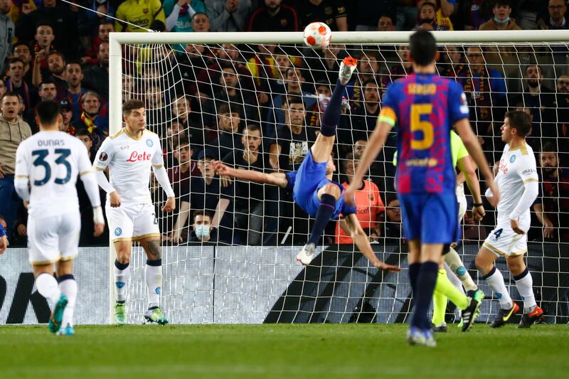 Barcelona's Luuk de Jong, center, makes an acrobatic attempt against Napoli. AP