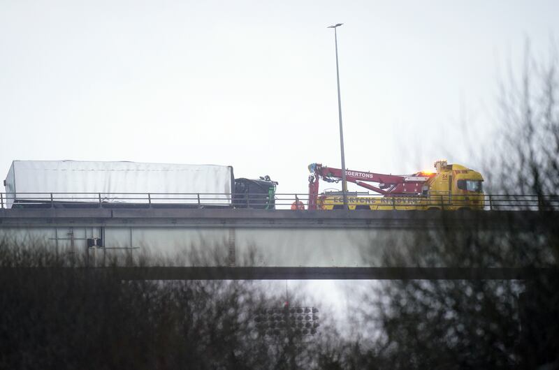 A lorry that overturned is towed on the M60 near Manchester. PA