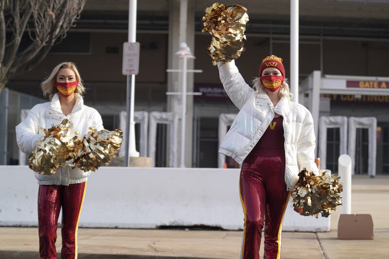 Cheerleaders don the new Washington Commanders logo outside of Fedex Field. Willy Lowry / The National.