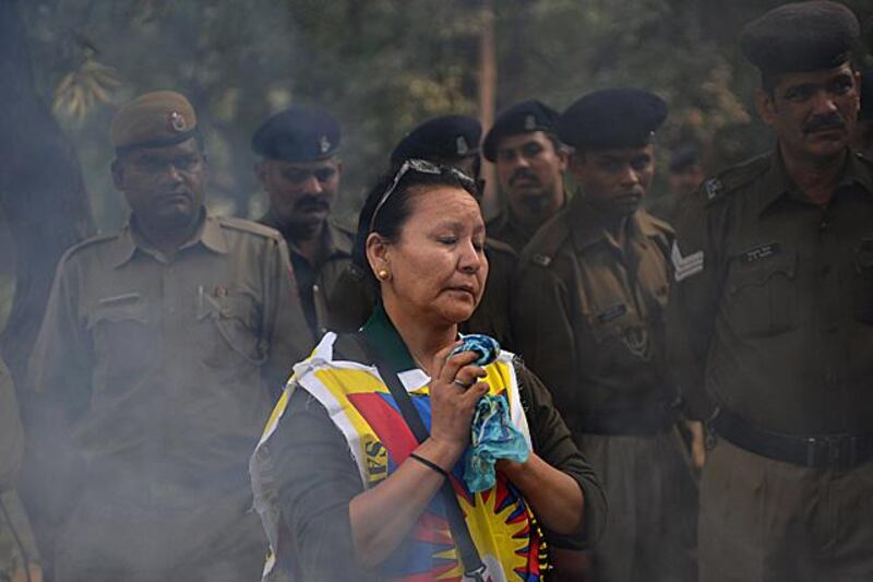 A Tibetan protester takes part in a prayer during an anti-Chinese rally by the Tibetan people's solidarity movement near the Chinese embassy in New Delhi on November 23, 2011. Tibetans marched close to the Chinese embassy to denounce Chinese rule in Tibet. Eight Buddhist monks and two nuns have set themselves alight in ethnically Tibetan parts of Sichuan province in China since the self-immolation of a young monk in March at Kirti monastery sparked a government crackdown. AFP PHOTO/ SAJJAD HUSSAIN

