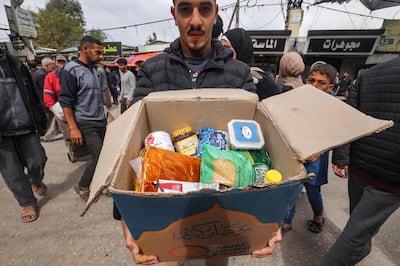 A man presents the contents of a cardboard box of food aid provided by non-profit non-governmental organisation World Central Kitchen in Rafah in the southern Gaza Strip on March 17, 2024. AFP