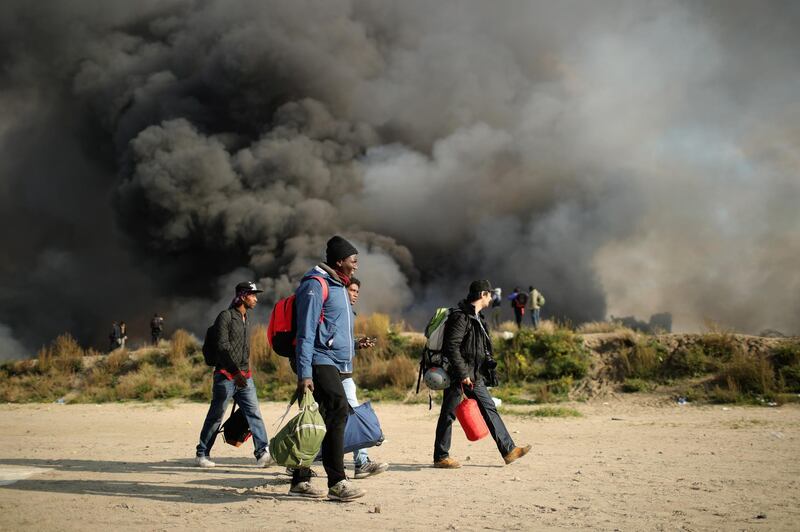 FILE - The Calais Jungle In 2016 CALAIS, FRANCE - OCTOBER 26:  Migrants pack up and leave notorious Jungle camp as authorities demolish the site on October 26, 2016 in Calais, France. Overnight fires broke out in many parts of the camp destroying shacks and makeshift shops along the camps main street. Many migrants have left by coach to be reloctated at centres across France.  (Photo by Christopher Furlong/Getty Images)