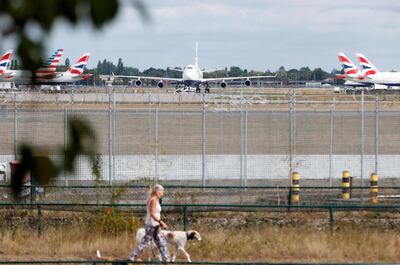 FILE PHOTO: A woman walks her dog past a British Airways Boeing 747 G-CIVD plane at London Heathrow airport, one of 31 jumbo jets to be retired early by the airline due to the coronavirus disease (COVID-19) pandemic, in London, Britain August 18, 2020. REUTERS/John Sibley/File Photo