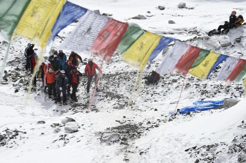 Rescue team personnel carry an injured person towards a waiting rescue helicopter at Everest base camp on April 26, 2015.