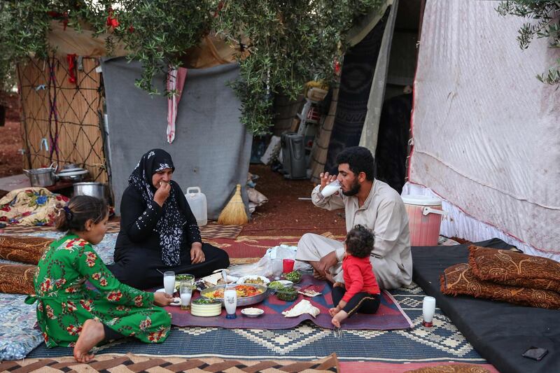 A displaced Syrian family break their fast in a field near a camp for displaced people in the village of Atme, in the jihadist-held northern Idlib province during the Muslim holy fasting month of Ramadan.   AFP