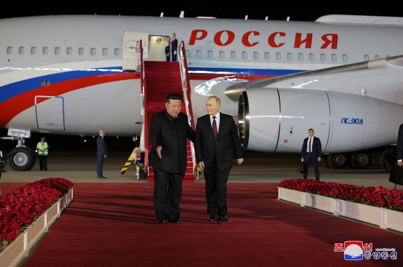 Mr Putin is welcomed by Mr Kim as he disembarks. Korean Central News Agency / Reuters