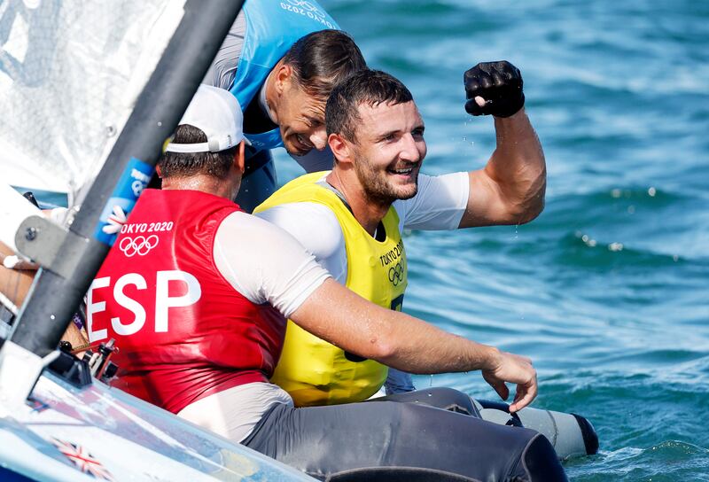 Gold medalist Giles Scott, centre, of Great Britain celebrates with bronze medalist Joan Cardona Mendez (red) of Spain and silver medalist Zsombor Berecz of Hungary after the Men's One Person Dinghy (Heavyweight) - Finn.