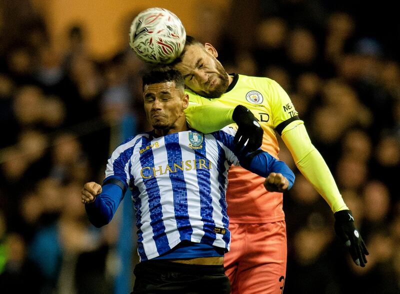 Shefield Wednesday's Jacob Murphy and Nicolas Otamendi of Manchester City challenge for a header. EPA