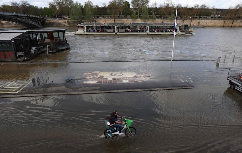 An electric bicycle ploughs through flooded docks on the banks of the Seine river in Paris. AFP