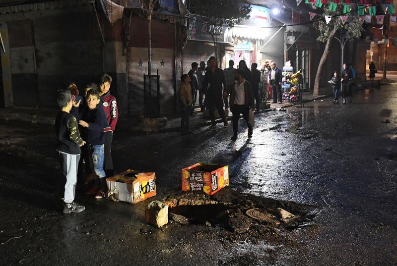 Syrian children stand around a whole on the road following a reported rocket attack in the government-held northern city of Aleppo on November 21, 2019. Rebel rocket fire on the government-controlled northern Syrian city of Aleppo killed seven civilians and wounded 30, state television said. "Seven civilians were killed and 30 more were wounded by a rocket attack carried out by terrorist groups," the official broadcaster said of rebel and jihadist factions in the west of Aleppo province. / AFP / -
