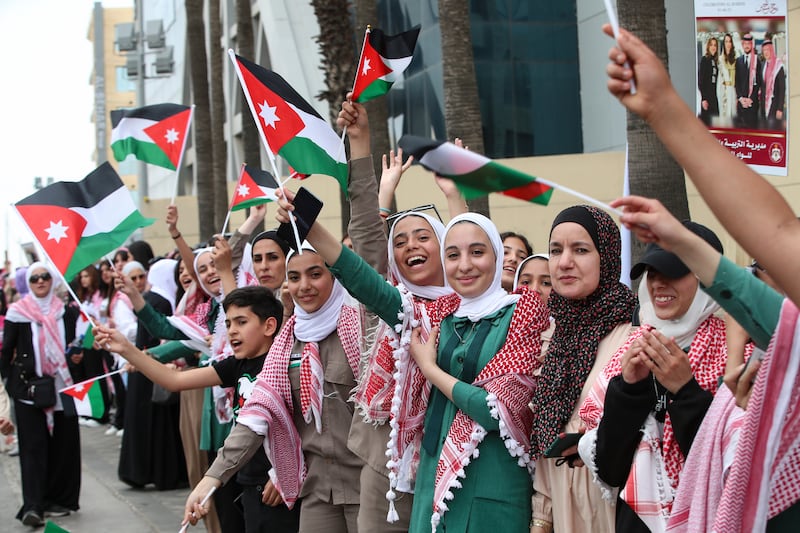 Jordanians wave national flags in the streets. AP