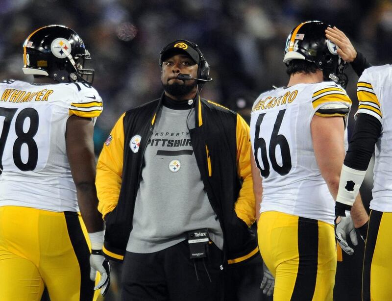 Pittsburgh Steelers coach Mike Tomlin stands on the sideline during a game against the Baltimore Ravens earlier this year. Tomlin has been fined $100,000 for interfering with a play against the Baltimore Ravens on Thanksgiving. The NFL also said it would consider docking Pittsburgh a draft pick "because the conduct affected a play on the field." Gail Burton / AP Photo