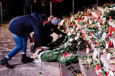 People leave flowers during a ceremony in Berlin marking five years since a lorry attack killed 12 people. Photo: AFP 