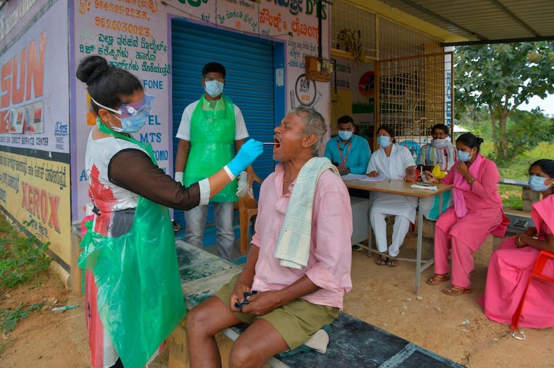 A health official collects a swab sample from a man to test for the coronavirus at a village on the outskirts of Bengaluru in south India. AFP