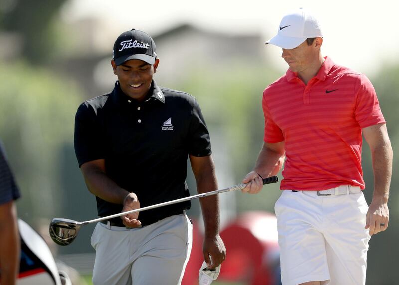DUBAI, UNITED ARAB EMIRATES - JANUARY 23:  Rayhan Thomas of India is handed back his driver by Rory McIlroy of Northern Ireland on the 18th hole during a practice round together as a preview for the Omega Dubai Desert Classic on the Majlis Course at The Emirates Golf Club on January 23, 2018 in Dubai, United Arab Emirates.  (Photo by David Cannon/Getty Images)