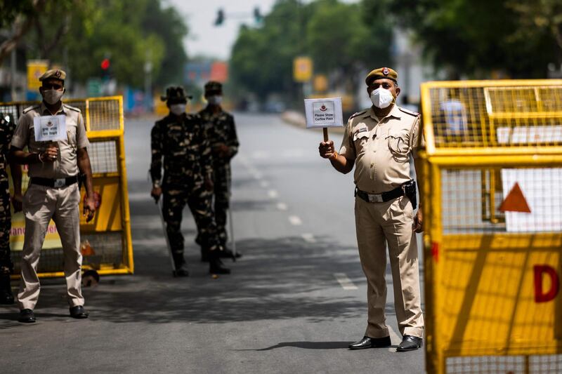 Policemen guard a roadblock in New Delhi on April 20, 2021, as India locked down its capital for a week beginning April 19 seeking to control a raging coronavirus outbreak. AFP