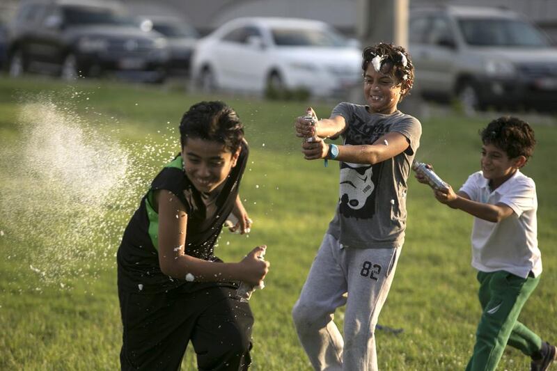 Young boys spray each other with foam and silly string in Abu Dhabi. Silvia Razgova / The National