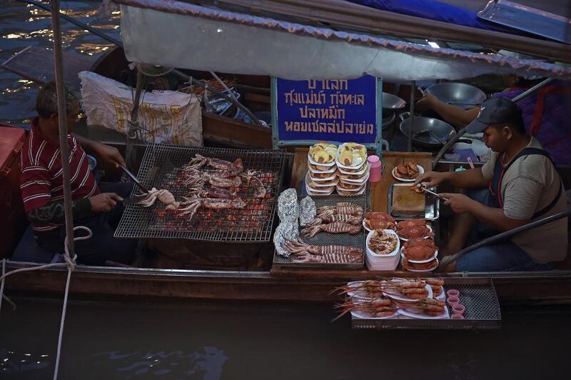 Vendors roast food on boats moored along the Amphawa canal, a small tributary of the Mae Khlong River, in Samut Songkhram province, about 80 kilometers west of Bangkok, Thailand. The canal turns into a floating market every weekend. Christophe Archambault / AFP
