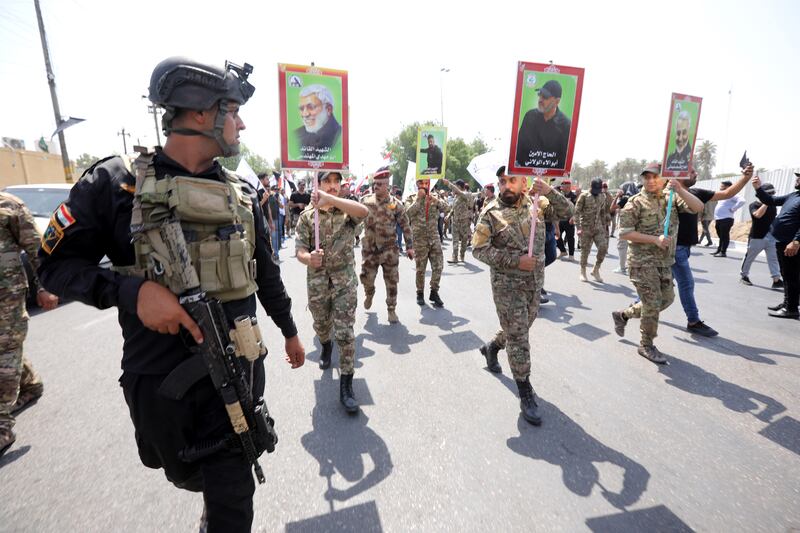 Supporters of Iran-backed Iraqi Shiite Popular Mobilisation Forces carry the pictures of their comrades who were killed in a US air strike near the Iraqi border with Syria. EPA
