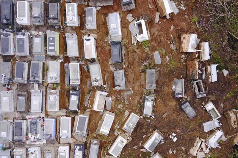 TOPSHOT - Coffins that were washed downhill from the Lares Municipal Cemetery by a landslide are seen in the aftermath of Hurricane Maria in Lares, Puerto Rico, September 30, 2017. 
US military and emergency relief teams ramped up their aid efforts for Puerto Rico amid growing criticism of the response to the hurricanes which ripped through the Caribbean island. / AFP PHOTO / Ricardo ARDUENGO