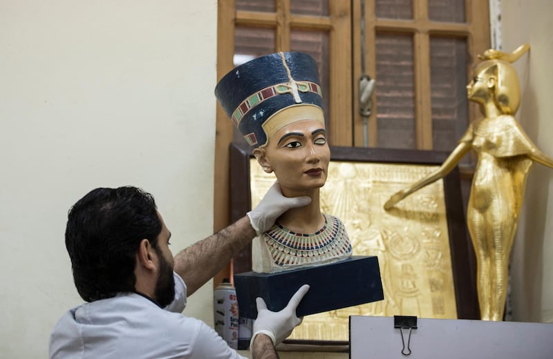 A worker holds a replica of statue of queen Nefertiti at the workshop of the Replica Production Unit located at Salah Al Din Citadel in Cairo, Egypt.  EPA