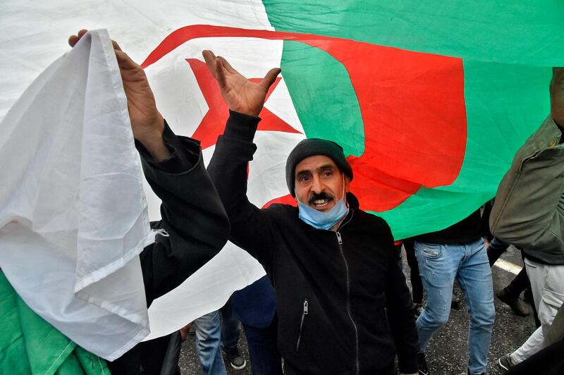 Algerians march with a national flag during a demonstration in the capital Algiers. AFP