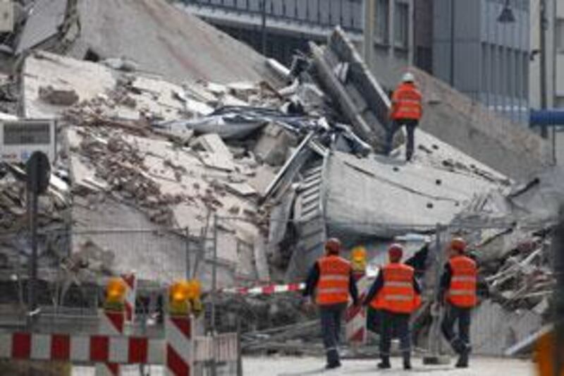 Members of emergency services search for people feared trapped underneath the rubble of the collapsed archive in Cologne.