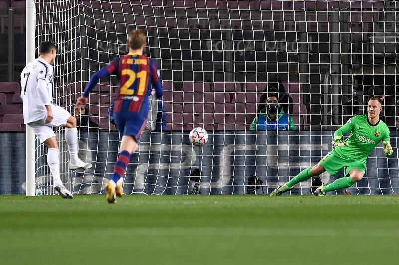 Juventus' Portuguese forward Cristiano Ronaldo (L) scores a penalty during the UEFA Champions League group G football match between Barcelona and Juventus at the Camp Nou stadium in Barcelona on December 8, 2020. (Photo by Josep LAGO / AFP)