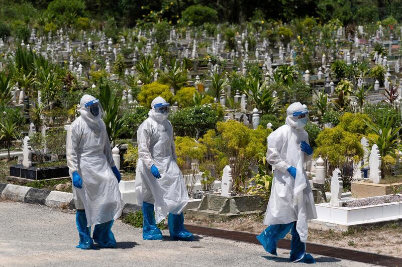 Workers leave after burying a victim of coronavirus at a Muslim cemetery in Gombak, outskirts of Kuala Lumpur, Malaysia. AP Photo