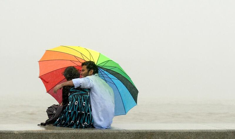 A couple share an umbrella at the sea front in Mumbai. A new course offered by the Presidency University in Kolkata aims to teach students about various aspects of love. Punit Paranjpe / AFP