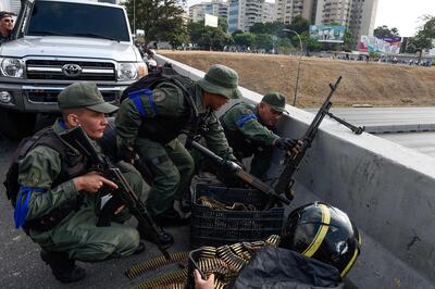 Members of the Bolivarian National Guard who joined Venezuelan opposition leader and self-proclaimed acting president Juan Guaido take position after repelling forces loyal to President Nicolas Maduro who arrived to disperse a demonstration in front of La Carlota military base in Caracas on April 30, 2019. Guaido -- accused by the government of attempting a coup Tuesday -- said there was "no turning back" in his attempt to oust President Nicolas Maduro from power. / AFP / Federico PARRA
