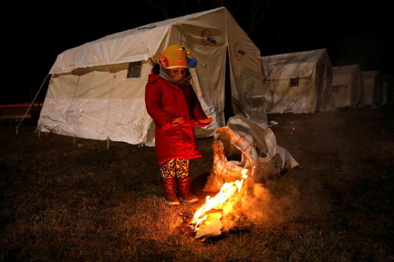 A child warms up outside tents following an earthquake in Elazig, Turkey. Reuters