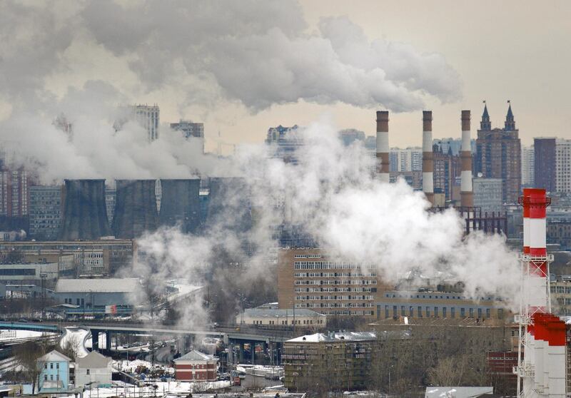 A picture taken on April 5, 2012, shows an aerial view of Moscow, with steam and smoke rising cooling towers and chimneys of  a coal-fired power plant in the foreground. AFP PHOTO / ALEXANDER NEMENOV (Photo by Alexander NEMENOV / AFP)