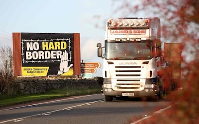 A lorry driver passes an anti-Brexit "No Hard Border" as he drives in Newry, Northern Ireland on October 16, 2019, on the road crossing the border between Newry and Dundalk in Ireland. British Prime Minister Boris Johnson briefed his ministers and key lawmakers on Wednesday on details of a Brexit deal taking shape in Brussels, while warning an agreement was still "shrouded in mist". Johnson also held talks earlier with leaders of Northern Ireland's Democratic Unionist Party (DUP) -- the third such meeting in three days. The DUP, which props up Johnson's minority government in parliament, is central to talks about future arrangements for the border between EU member Ireland and British-run Northern Ireland. / AFP / Paul Faith
