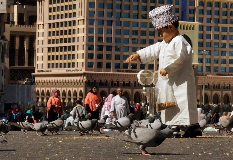 A boy feeds pigeons outside the Grand Mosque in the Muslim holy city of Mecca, Saudi Arabia. AP Photo
