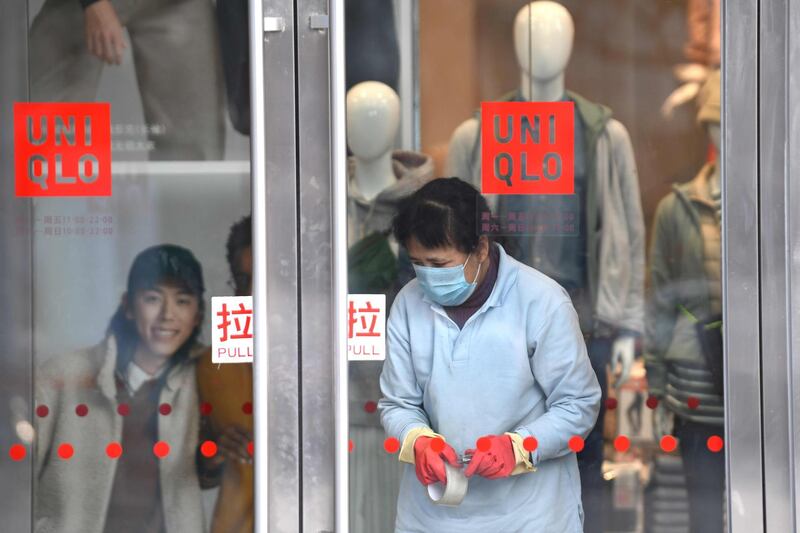A worker wearing a protective mask is seen inside a shop at a mall in Beijing. AFP