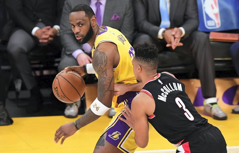 (FILES) In this file photo LeBron James of the Los Angeles Lakers looks to pass under pressure from CJ McCollum of the Portland Trailblazers on January 31, 2020 during their NBA game in Los Angeles. - NBA superstar LeBron James was among the US athletes taking to social media in outrage over the death of a black man in Minnesota after a white policeman kneeled on his neck for several minutes. Four Minneapolis police officers were fired May 26, 2020 as a video showing one of them kneeling on the neck of George Floyd, a handcuffed black man who later died, sparked protests. (Photo by Frederic J. BROWN / AFP)