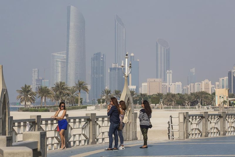 A woman poses for photos at the Corniche. The adjoining road was built on reclaimed land in 2003 and 2004. Mona Al Marzooqi / The National