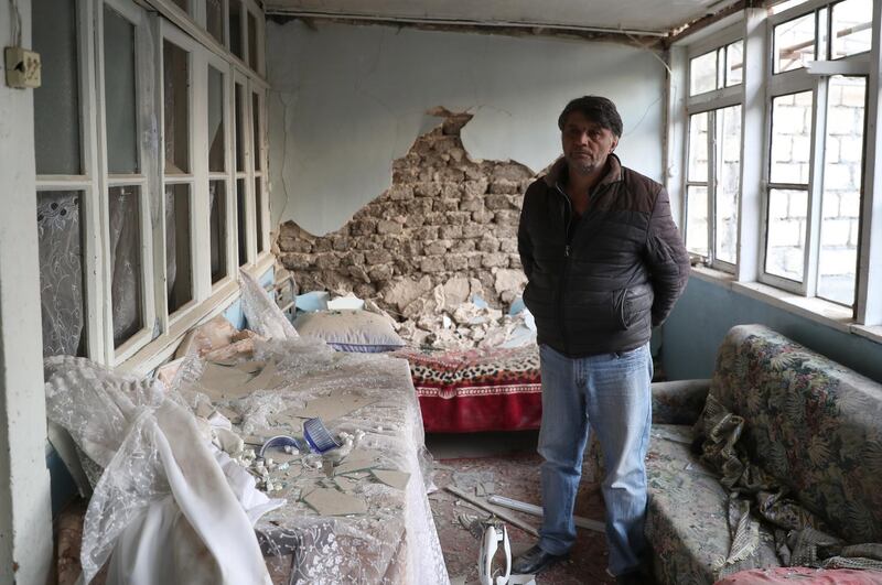 A local resident stands inside a house allegedly damaged by recent shelling in Ganja, Azerbaijan. EPA