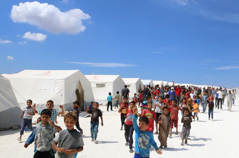 TOPSHOT - Displaced Syrians take part in a protest against the regime and its ally Russia at a camp for displaced people in Kafr Lusin near the Bab al-Hawa border crossing with Turkey in Syria's northern Idlib province on September 7, 2018. (Photo by Aaref WATAD / AFP)