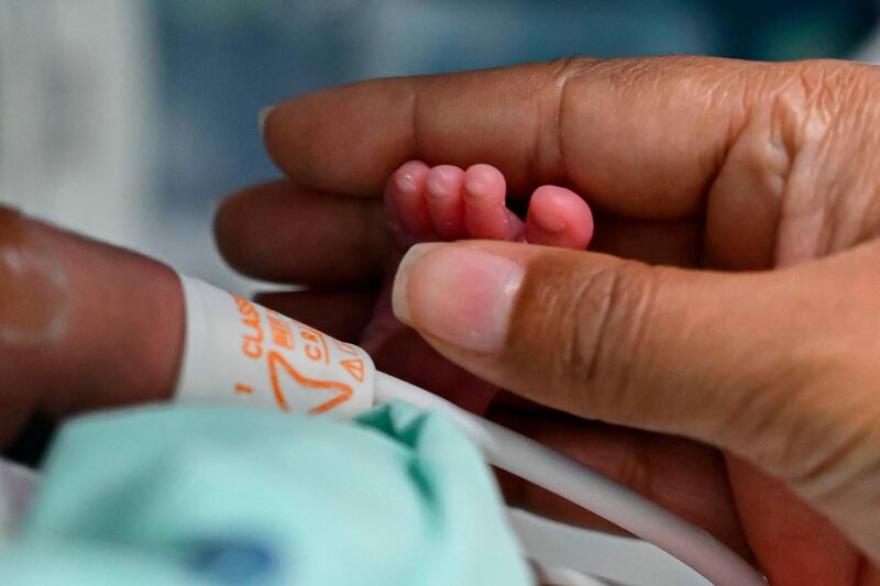 Diana Paola Angola who recovered of the novel coronavirus, COVID-19, caress her son Jefferson at the neonatal room in the Versalles Clinic, in Cali, Colombia. AFP