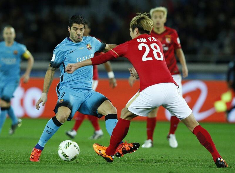 Luis Suarez, left, and Guangzhou Evergrande’s Kim Young-gwon fight for the ball. Toru Hanai / Reuters