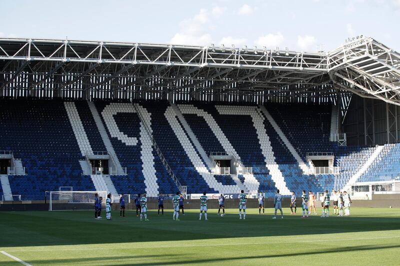 Players observe a minute of silence to honor the victims of coronavirus ahead of the match. AP