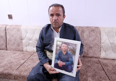 Mohammad Taha, with a picture of his son Redar, who is still missing, in Deraluk, Kurdistan. Chris Whiteoak / The National