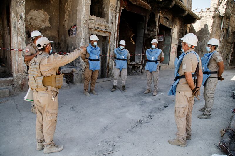 A member of a demining squad gives directions during an operation to clear mines in the Old City of Mosul.