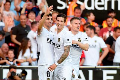 Valencia's French forward Kevin Gameiro (R) celebrates with Valencia's Spanish midfielder Carlos Soler (L) and Valencia's Spanish forward Santi Mina after scoring a goal during the Spanish League football match between Valencia and Alaves at the Mestalla Stadium in Valencia on May 12, 2019. / AFP / JOSE JORDAN
