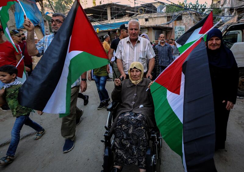 epa07671187 Palestinian wave their national flag and shout slogans against the Bahrain Conference, and the so-called 'century deal' during an angry rally organized by "factions of the Palestine Liberation Organization" and the "Fatah" in the Bourj Barajneh Palestinian refugees camp, in southern suburb of Beirut, Lebanon 24 June 2019. Palestinians gathering in all the Palestinian refugee’s camps in Lebanon to protest against the Bahrain Conference and the so-called 'century deal' planned by US President Donald J. Trump to solve the conflict between Palestine and Israel.  EPA/Nabil Mounzer