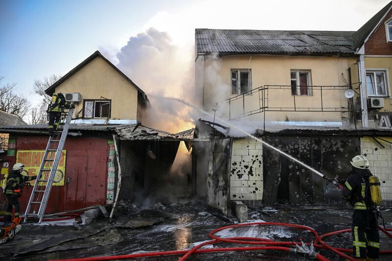 Firefighters extinguish a blaze at a house after shelling in Kyiv. AFP
